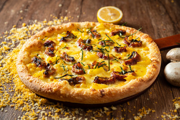 whole italian pizza on wood table with ingredients