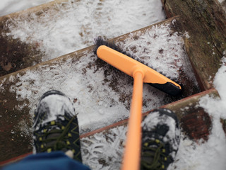 removing snow from the wooden steps