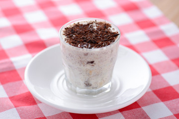 Pancho cake dessert with sour cream, walnuts and chocolate served in a glass. Copy space for text.