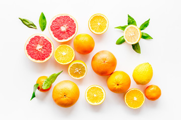 Fototapeta na wymiar Fresh citrus background. Oranges, grapefruits, leaves - whole fruits and halfs - on white background top-down