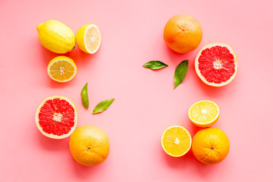 Citrus pattern. Cut lemon and grapefruits and leaves on pink background top-down