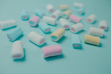 Colorful marshmallow on blue background. Many candies on the table.