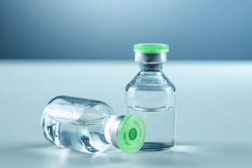 Vaccine in vial and syringe close-up on a white table gray background, medical concept, laboratory,...