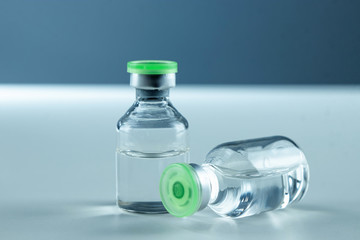 Vaccine in vial and syringe close-up on a white table gray background, medical concept, laboratory,...