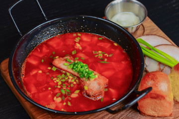 Traditional Ukrainian Russian vegetable borscht. Ukrainian beetroot soup in a bowl with meet, greenery and garlic bread