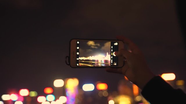 Young Woman Using Smartphone in the City,Taking Pictures.Girl using cell phone photography app,4K before of Hong Kong laser light show at Victoria hobour, the most popular tourist popular viewpoint.