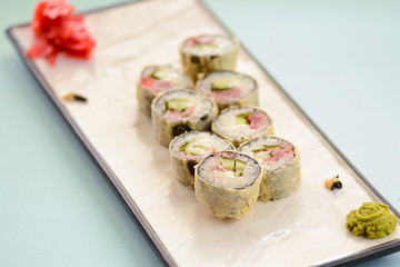 Maki Sushi California fried hot rolls with fresh salmon, cucumber and cream cheese philadelphia inside on white plate