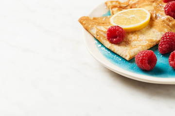 Folded pancakes on white marble background