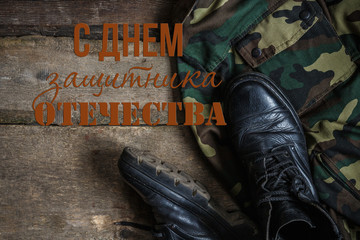 Army military uniform, weapon, holster, pistol, flask, boots on wooden background. Flat lay top...