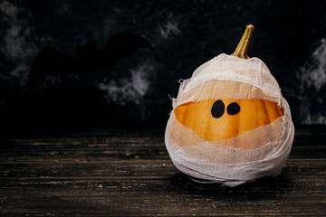 Zombie pumpkins in bandages, on a dark background. The concept of Halloween