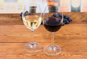 Two glasses of red and white wine on rustic table