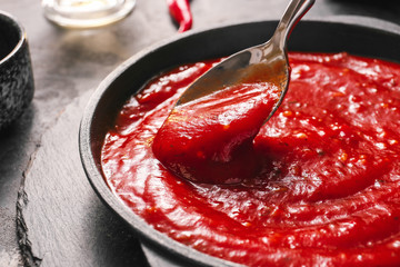 Pan with tomato sauce on table, closeup