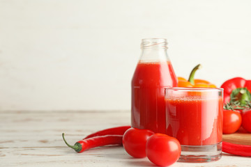 Glass and bottle of fresh vegetable juice on table