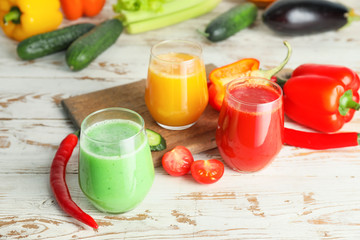 Glasses of fresh vegetable juices on white table