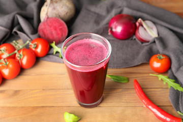 Glass of fresh vegetable juice on table