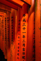 Detail of kanjii letters carved in the red torii gates at Fushimi Inari shrine, Kyoto, Japan