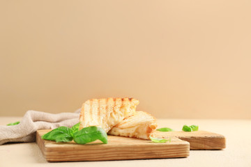 Board with tasty sandwiches on table