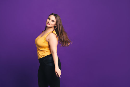 Plus size fashion model in casual clothes, fat woman on purple background