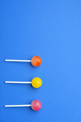 Tasty lollipops on color background
