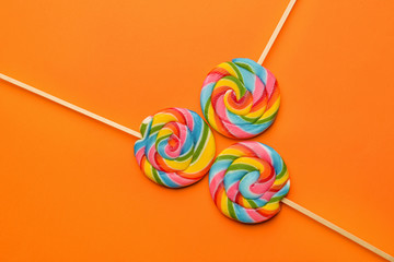 Tasty lollipops on color background