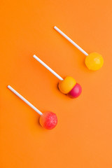 Tasty lollipops on color background