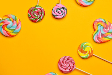 Tasty lollipops on color background