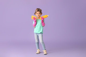 Little housewife with cleaning supplies on color background