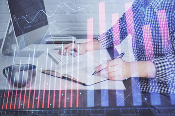 Double exposure of stock market chart with man working on computer on background. Concept of...