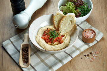 Close up view on tasty plate of arabic, israel or lebanese vegetarian hummus made from chickpeas...
