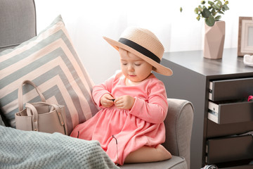 Cute baby girl with stylish accessories at home