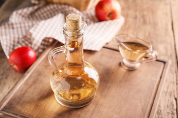 Obraz na płótnie Canvas Apple cider vinegar on wooden table
