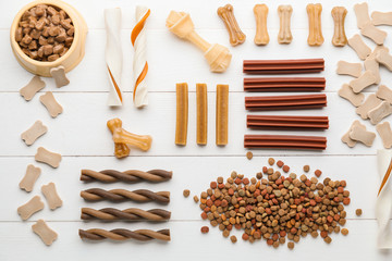 Different pet food on white wooden background