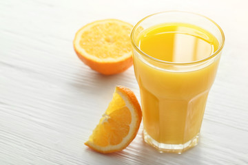 Glass of fresh orange juice on table