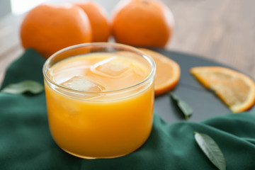 Glass of fresh orange juice on table