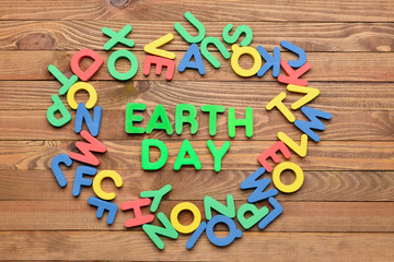 Composition with text EARTH DAY on wooden background
