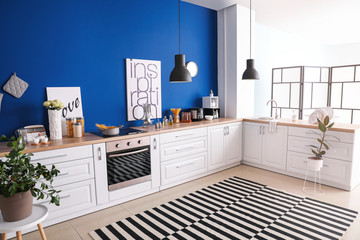 Interior of modern kitchen with blue wall