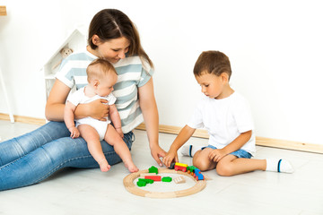 Mother Sitting With kids playing game Indoors