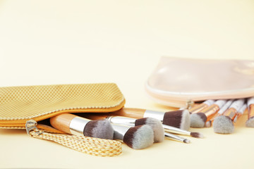 Set of makeup brushes on color background