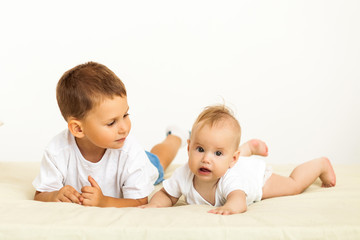 Portrait of brother and sister. Two cute children lying on bed