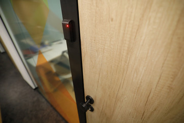 Shallow depth of field (selective focus) image with the locked wooden door inside an office building.