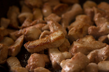 turkey fillet marinated in tomato sauce or chicken fillet fried in a black pan