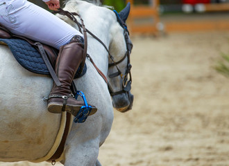 Horse with rider at a tournament, close-up of riding boots with spurs in the stirrups!.