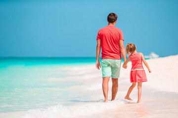Fototapeta na wymiar Little girl and happy dad having fun during beach vacation