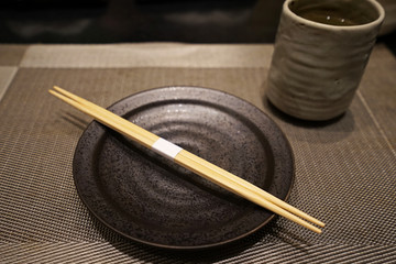 Fototapeta na wymiar Close up Wooden chopsticks on ceramic plate