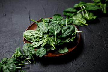 fresh spinach leaves on dark backgrownd. Top view