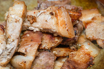 Fried pieces of meat are fried in a pan close up