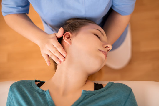 Female physiotherapist or a chiropractor adjusting patients neck. Physiotherapy, rehabilitation concept. Top view close up.