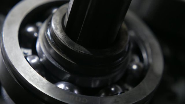Car crankshaft fixed to a ball bearing and cogwheels rotating in an auto gearbox  