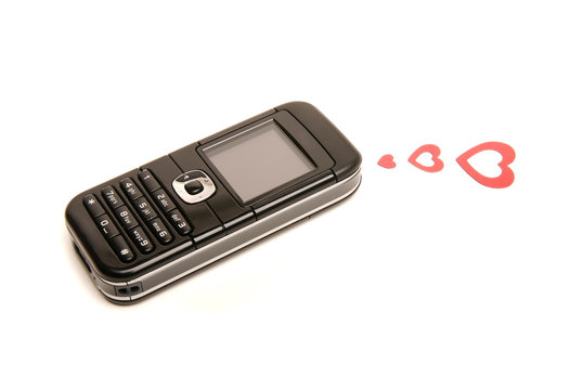 Old fashioned mobile phone on white background with three red hearts sending out a love message
