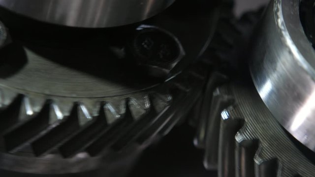 Whirling choppers of two wide cogs riding fast in a present-day car transmission 